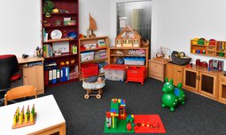 Spielzimmer mit mehreren Spielelementen und einer Spielküche | © Caritasverband der Erzdiözese München und Freising e.V.